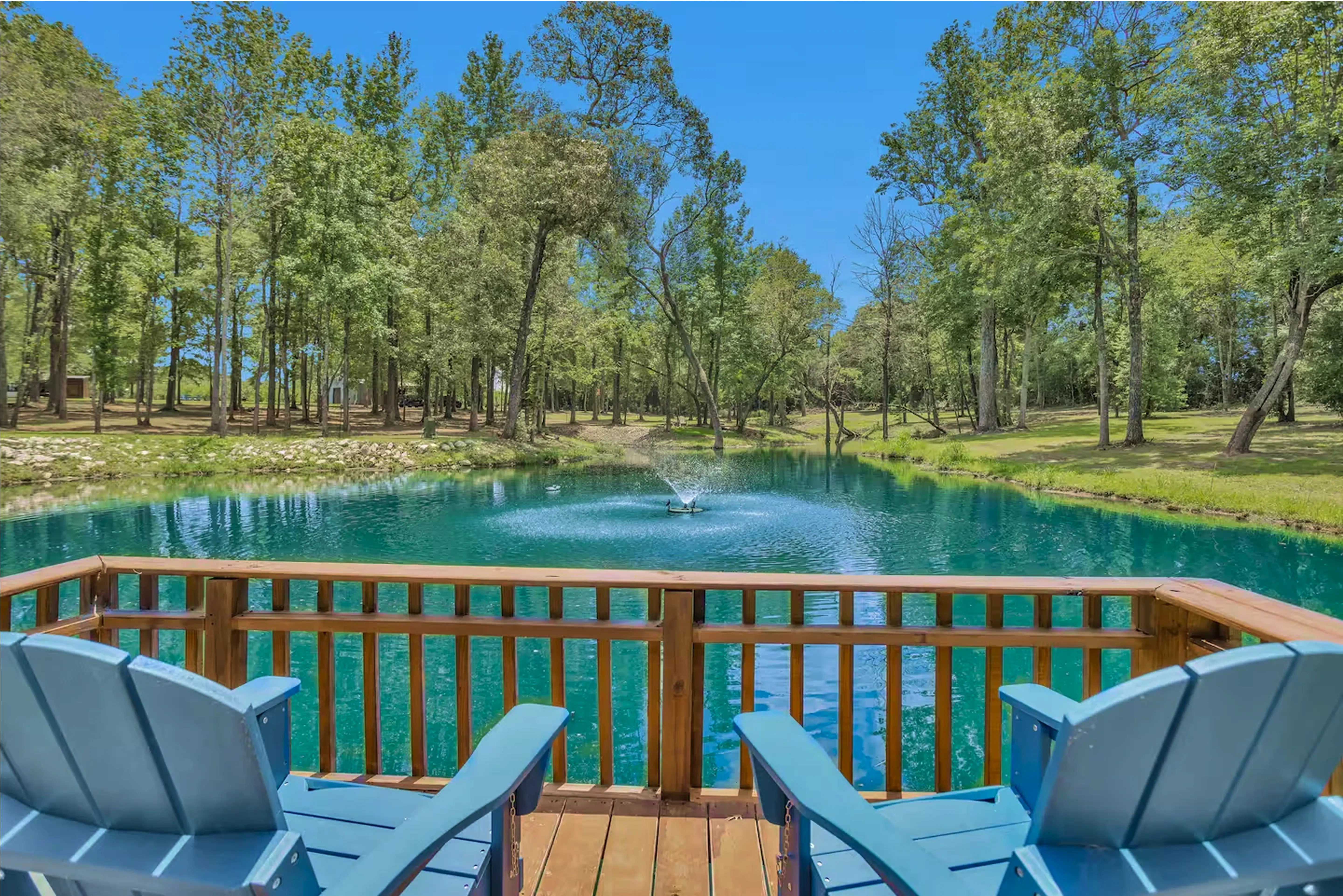 Beautiful of our signature blue pond, with 2 chairs facing the water